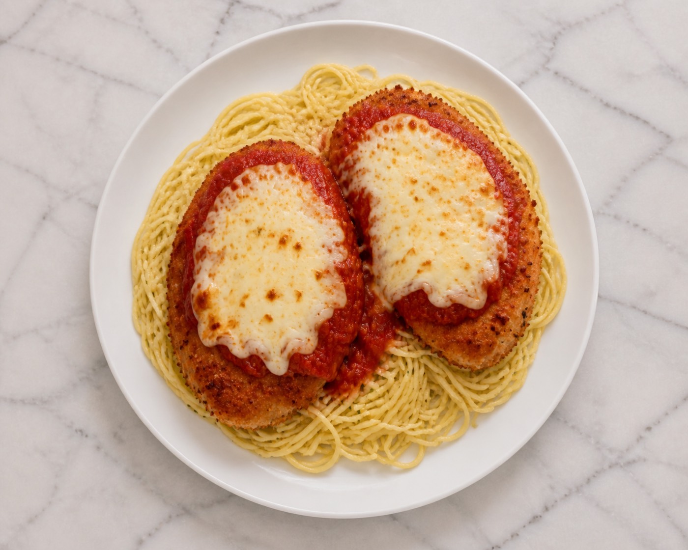 Chicken Parm, Properly, photographed on white marble in the A More Perfect Supper kitchen