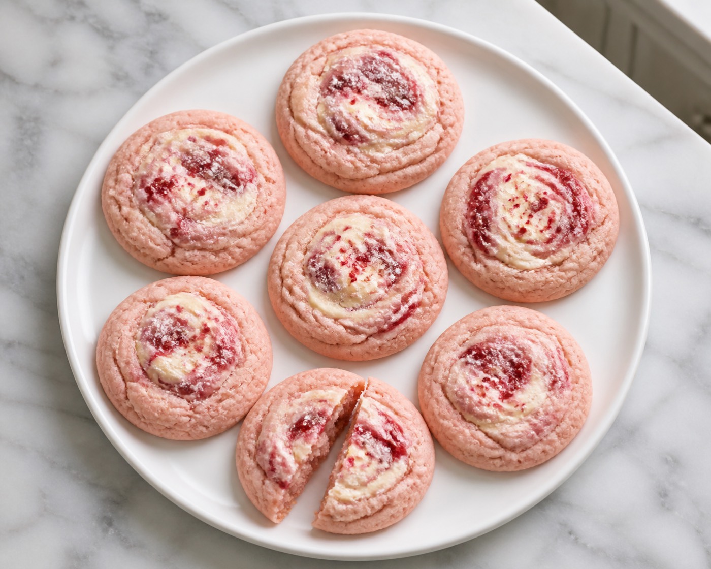 Strawberry Cheesecake Swirl Cookies, photographed on white marble in the A More Perfect Supper kitchen